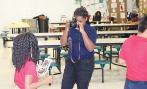Ma’liya James, a fourth-grader and a member of the schools Manatee Messenger staff documents the distribution of the first edition of the school’s paper.